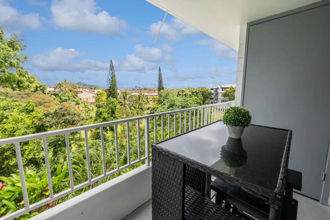 Private lanai with a bistro set overlooking lush greenery