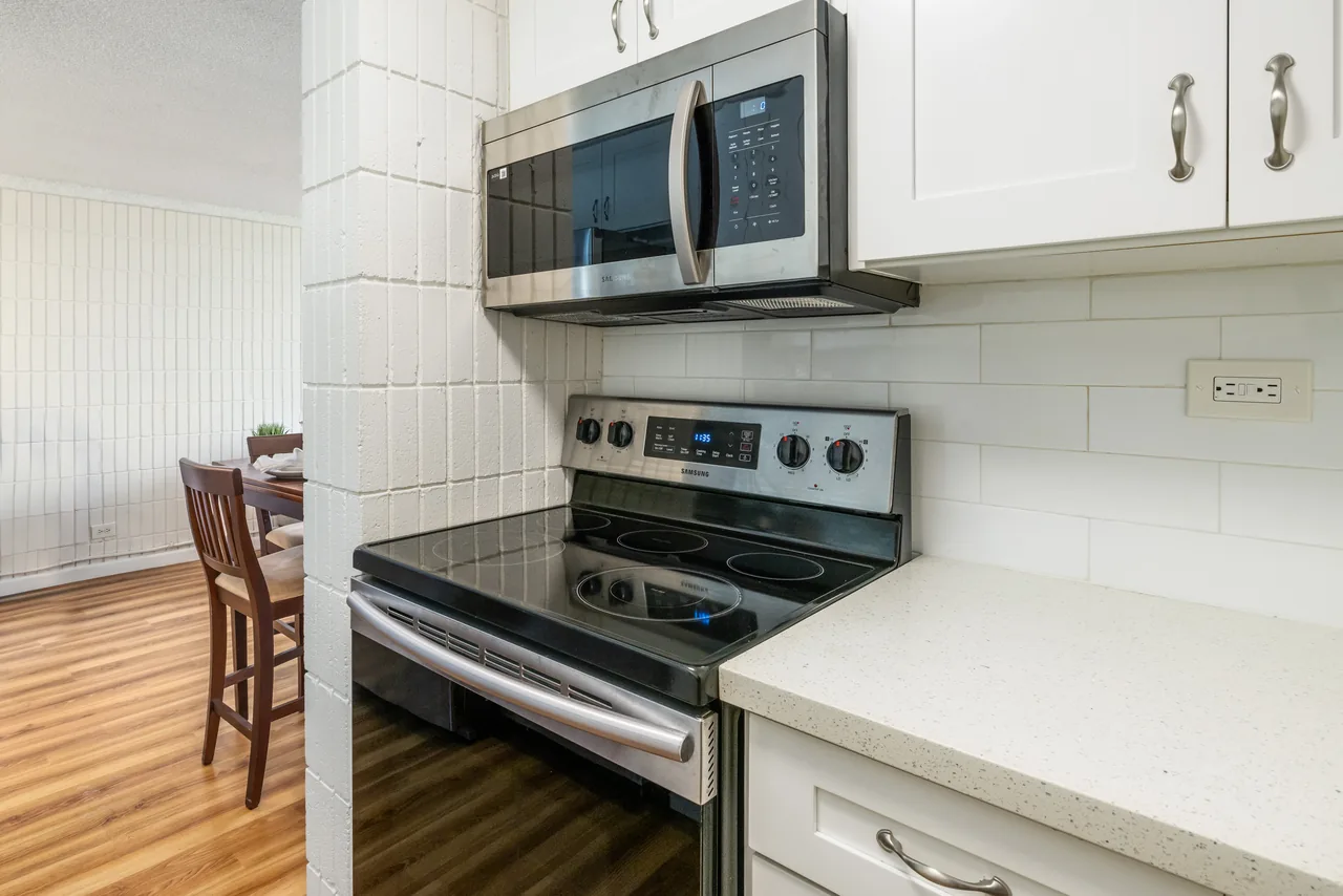 Full kitchen with a stainless range, microwave and bright counters