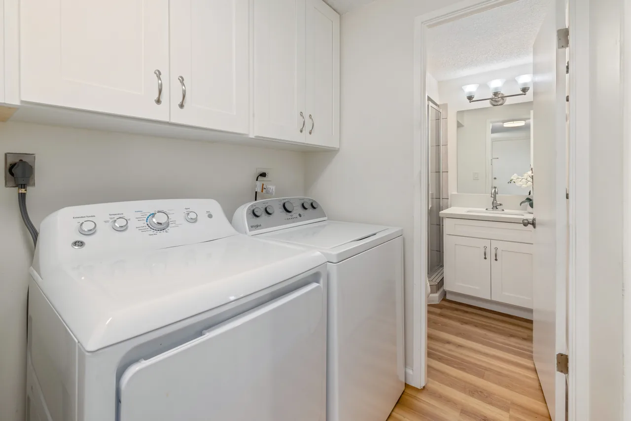 In-unit washer and dryer with a bathroom vanity beyond