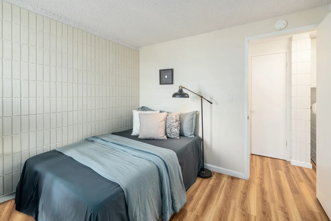 Bedroom with a queen bed dressed in calm teal bedding