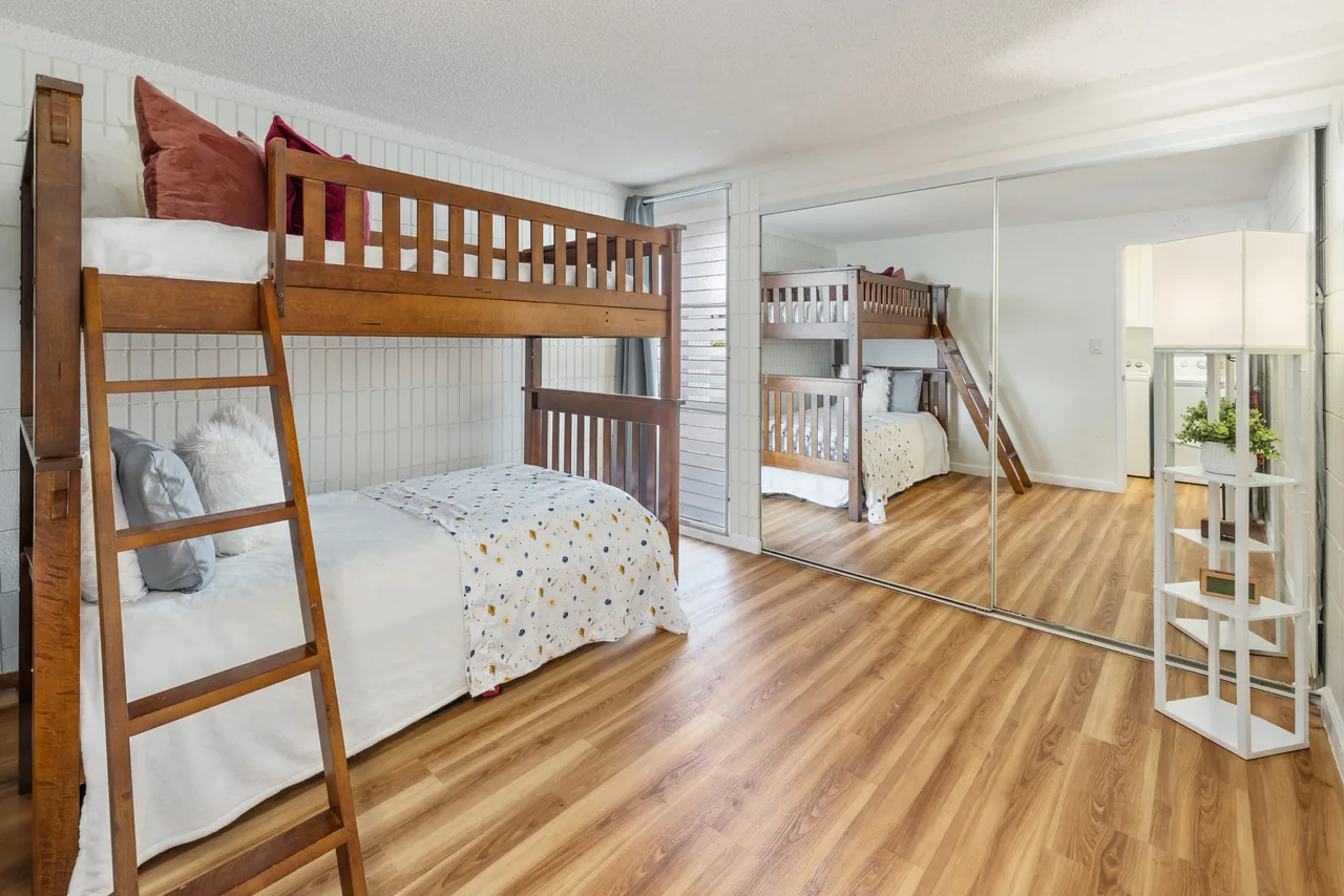 Guest room with a twin-over-full bunk bed and honey-oak floors
