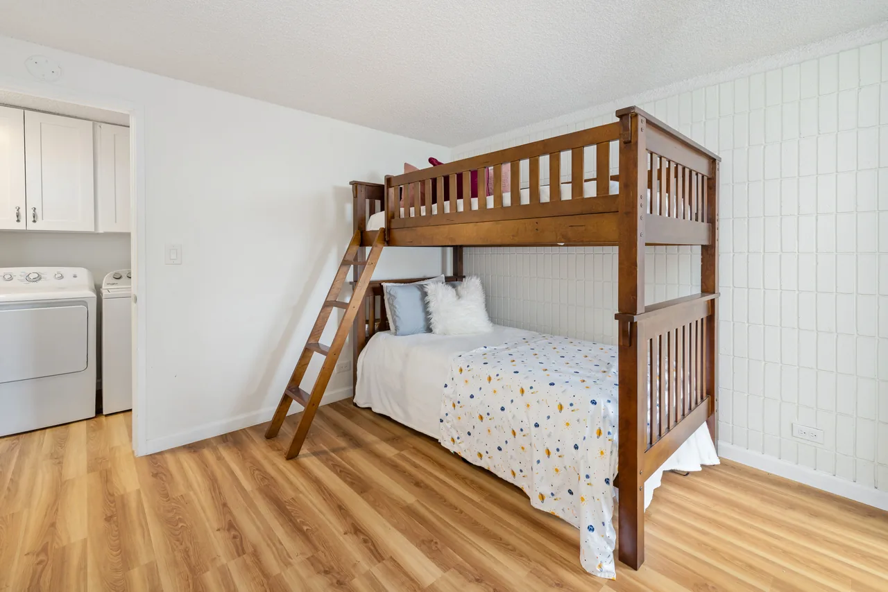 Bunk-bed bedroom with an adjacent in-unit washer and dryer