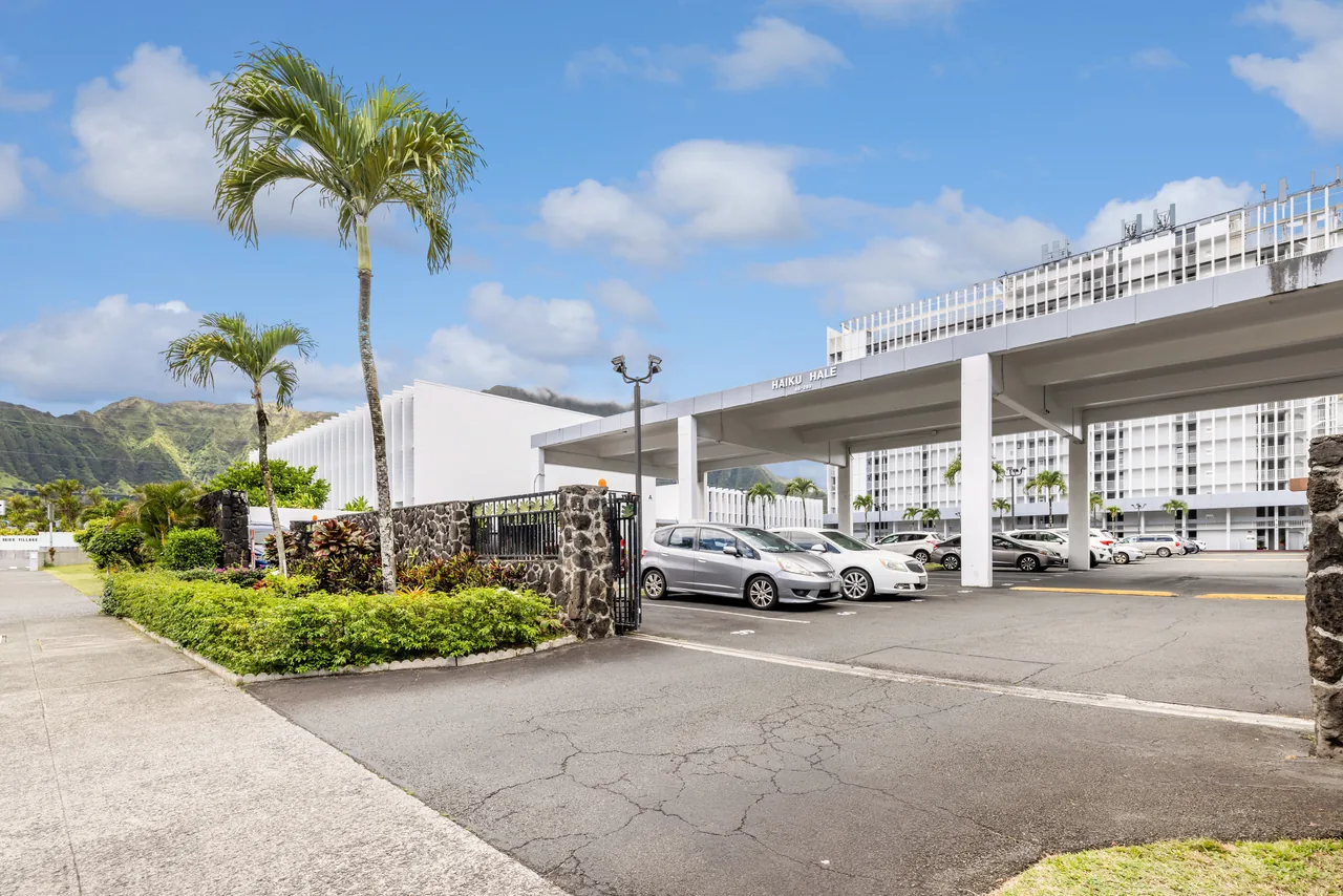 Haiku Hale building exterior with covered parking and palm trees