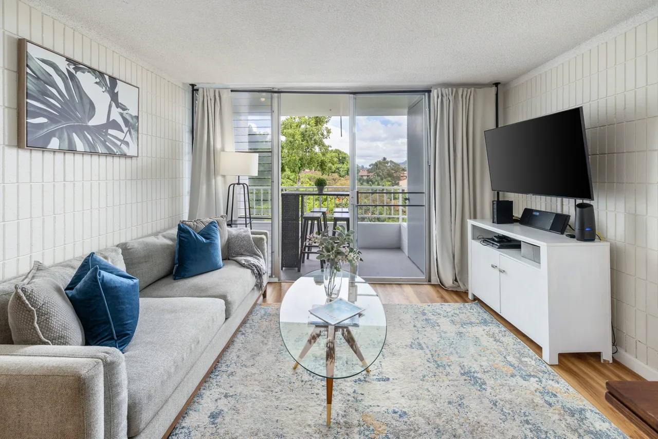 Living room with a comfortable sofa, smart TV and sliding doors opening to the lanai