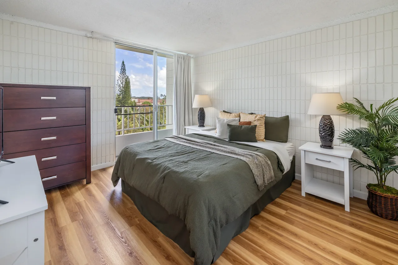 Restful bedroom with a dresser and nightstand lamps beside a bright window
