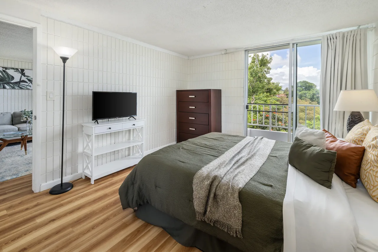 Furnished bedroom with a dresser and TV and mountain views through the window