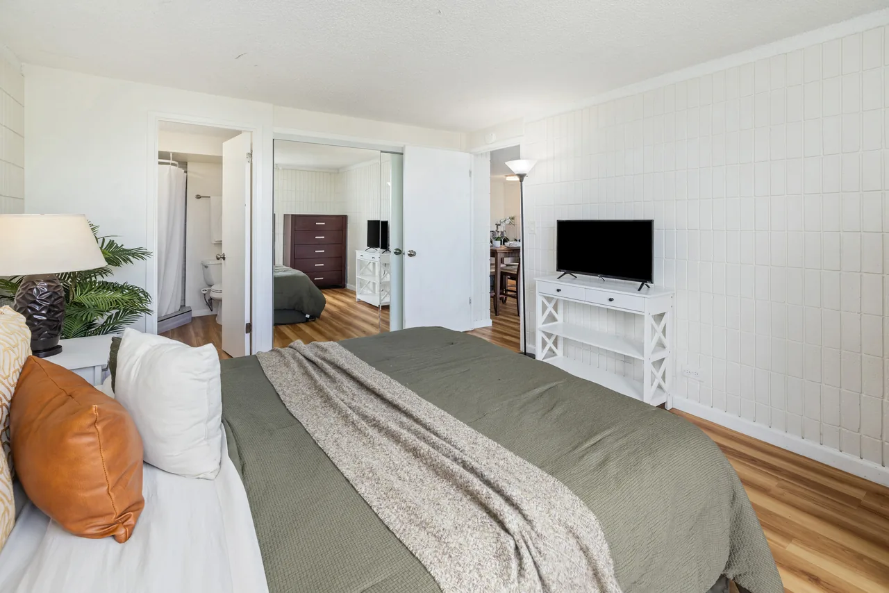 Comfortable bedroom with a smart TV, opening toward the hallway